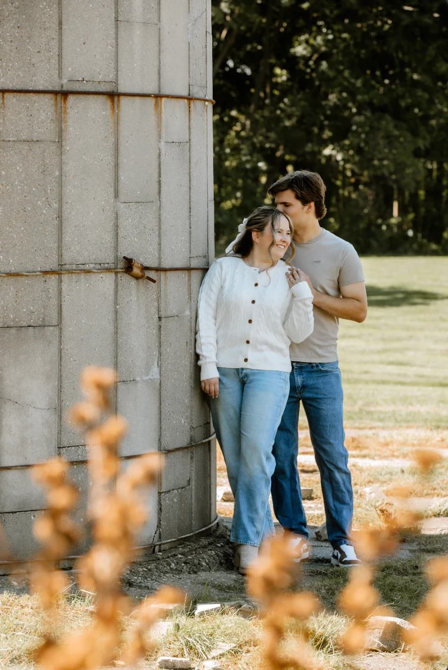 Gavin and Ally leaning together against an old concrete silo